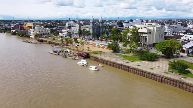 Aerial Majesty of Quibd&oacute;: River, Faith, and Rainforest. Drone views of Quibd&oacute;, Choco, Colombia, featuring the Atrato River, boats, rainforest, and the iconic cathedral. A vibrant mix of nature.