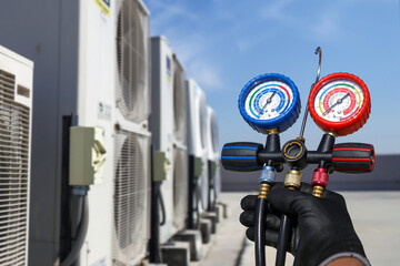 Electrical technician use manifold gauge check and filling refrigerant vacuum pump evacuates...