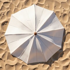 White beach umbrella against sandy texture background  