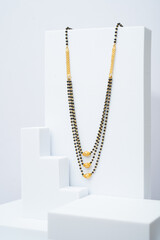 Indian neckless called as Mangalsutra on creative white background. Creative jewelry photo of...