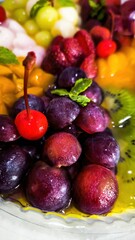 A vibrant and colorful fruit medley in jelly, featuring grapes, cherries, strawberries, kiwi, and melon