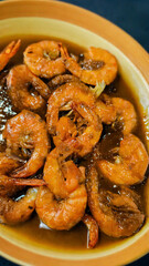 Delicious shrimp sauteed in flavorful sauce served in a bowl close-up view