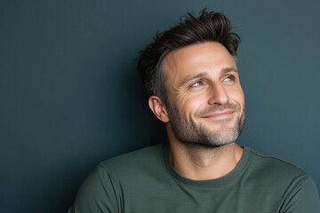 Fototapeta premium Excited smiling young clean shaven modern man, looking slightly upwards at an side angle.