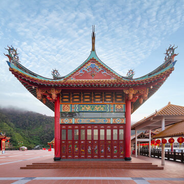 Chin Swee Caves Temple in Genting Highlands, Malaysia, showcases intricate architecture and vibrant colors, set against a backdrop of lush mountains and a clear sky