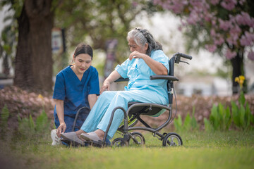 Nurse caregiver with elderly woman enjoying beneath blooming trees. suggesting in healthcare...