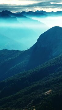 Gorgeous mountains in blue mist. Amazing view of the mountain range in California overgrown with greenery. Top view. Vertical video