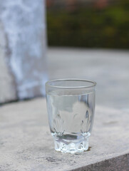 water in a glass on a cement floor isolated Bokeh background