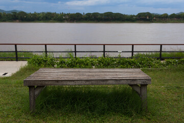 Fototapeta premium Serene riverside bench tranquil park outdoor seating nature view relaxing atmosphere scenic environment