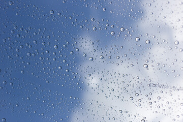 Raindrops on glass outdoor setting nature photography cloudy sky close-up view calm atmosphere