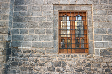 The ancient wooden window on an old building wall with a large rock texture. There is a copy space area, suitable for use as a background with a horror theme
