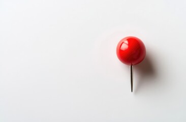 Close-up of a bright red pushpin on white background.