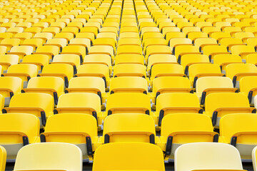 Rows of empty yellow stadium seats creating a repetitive pattern in a sports arena background perspective.