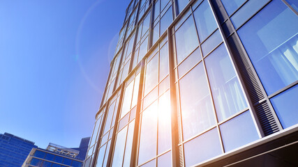 Modern office building with glass facade on a clear sky background. Transparent glass wall of office building.