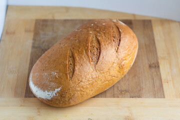 Freshly Baked Loaf of Bread on a Wooden Cutting Board