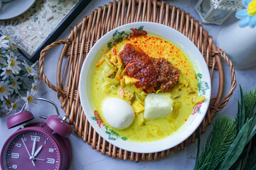 Lontong, a traditional Southeast Asian dish of compressed rice cakes in rich coconut curry, served...