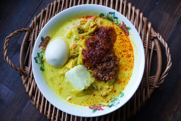 Lontong, a traditional Southeast Asian dish of compressed rice cakes in rich coconut curry, served...