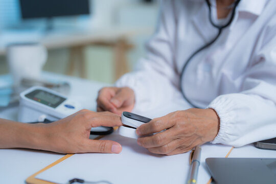 Doctor measuring blood oxygen saturation of patient using pulse oximeter in hospital or clinic, highlighting essential healthcare and medical practices for monitoring vital signs and overall health - Powered by Adobe