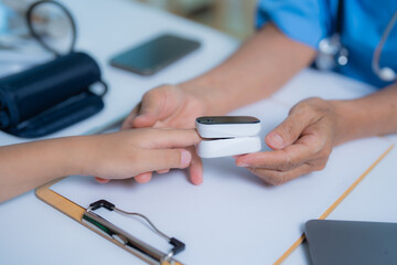 Doctor is using pulse oximeter to measure blood oxygen saturation level of patient in hospital or...