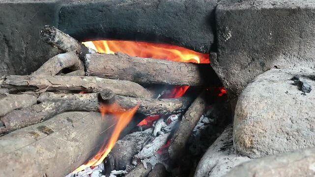 Close up of cooking using firewood as the main fuel on a traditional stove in an old kitchen in the village.
