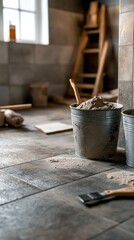 A tiler is laying new tiles on a bathroom floor while using adhesive and various tiling tools. The workspace shows preparations for a complete renovation project