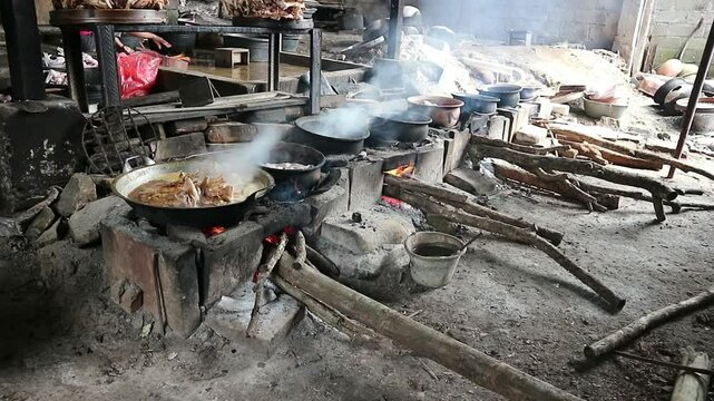 The process of roasting whole chicken meat by roasting it on a wood stove in a traditional and simple way, the meat is skewered with bamboo so that it roasts evenly.
