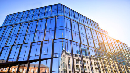 Modern office building with glass facade on a clear sky background. Transparent glass wall of office building.