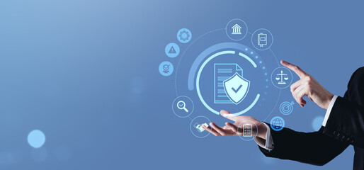 Businessman interacting with digital data protection interface on blue background.