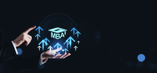 Businessman pointing at glowing MBA icon with upward arrows and graduation cap on dark background,...
