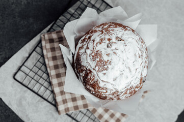 Top view of Easter sweet bread with sugar crust in baking paper. Festive baked dessert for spring celebration..