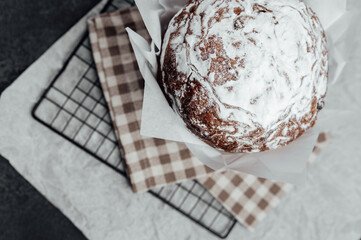 Top view of Easter sweet bread with sugar crust in baking paper. Festive baked dessert for spring celebration..
