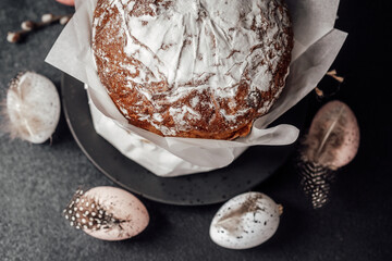 Easter cake with decorated eggs and rustic composition. Spring holiday food styling on dark background