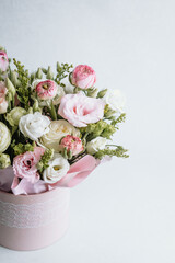 Beautiful bouquet of pastel flowers in a decorative pot on a light background