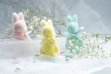 Colorful marshmallow bunnies surrounded by flowers on a soft backdrop