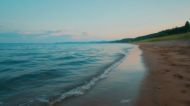 Sandy beach, calm water, evening sky, distant land.