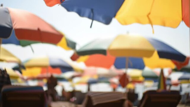 A Colorful Array of Beach Umbrellas Topping a Sunlit Sandy Shoreline with Lounge Chairs Ready for Relaxation on a Warm Summer Day