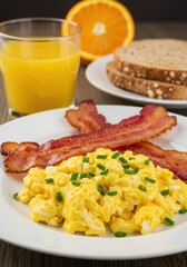 Scrumptious Breakfast: Scrambled Eggs with Crispy Bacon, Orange Juice and Whole Wheat Bread