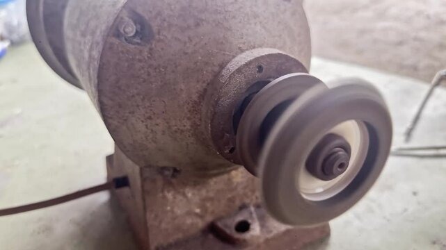 Powerful electric angle grinder with interchangeable cutting and grinding discs being for metal fabrication, construction, DIY repair projects. Sparks fly the tool precisely shapes finishes materials.