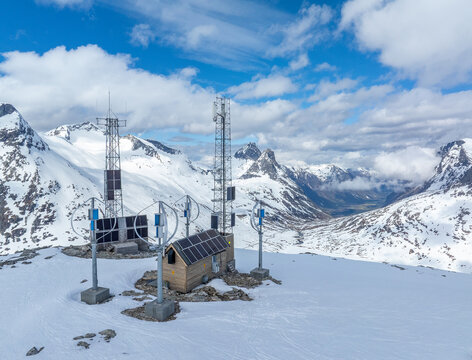 TV and mobile phone mast on top of winter mountain, powered by solar cells and wind turbines. Norwegian mountain landscape not far from Trollstigen. - Powered by Adobe