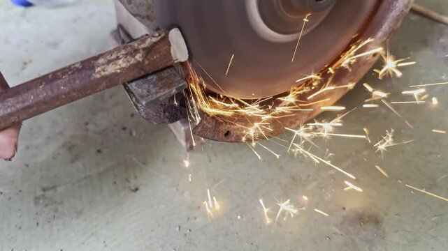 Powerful electric angle grinder with interchangeable cutting and grinding discs being for metal fabrication, construction, DIY repair projects. Sparks fly the tool precisely shapes finishes materials.