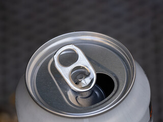 Close-up of an opened aluminum beverage can with a pull tab.