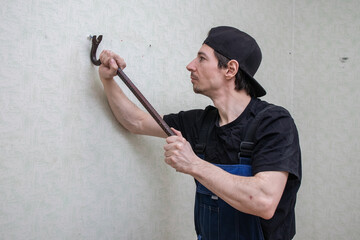 Worker pulling dowel with crowbar (1)