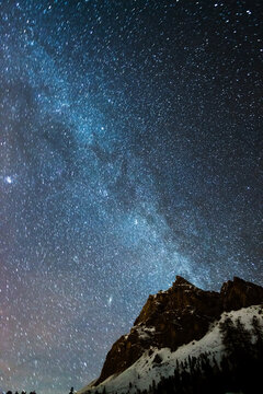 Milky way over peak in the Dolomites in winter, Italy
