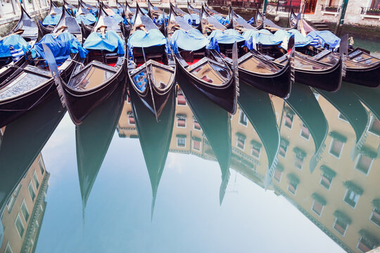 Row of gondolas reflected into water, Venice, Italy