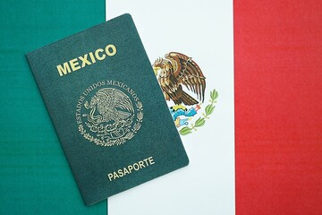 Mexican passport lies on Mexico flag close up. Travel and citizenship