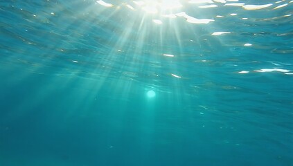 Light rays penetrate clear turquoise water creating an abstract underwater environment that captivates the senses