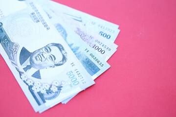 North Korean won money bills in big amount lies on red color table close up