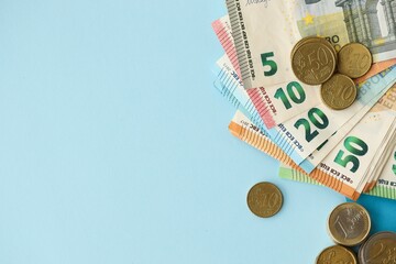 European union Euro money bills and coins on blue table