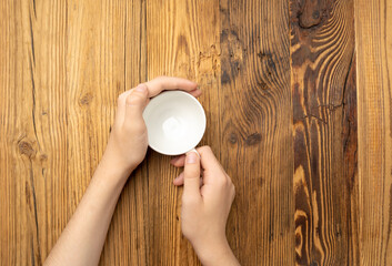 Hand Holds Cup, Empty White Cup in Hands, Coffee Mug, Teacup Mockup, Cup in Arms on Wooden Table