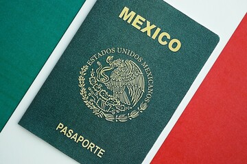 Mexican passport lies on Mexico flag close up. Travel and citizenship