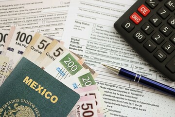 Mexican pesos money bills in big amount lies on table with pen, calculator, passport and tax forms